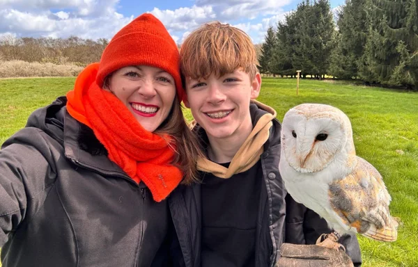 Family on the owl encounter with a barn owl. Mother and son with smiles